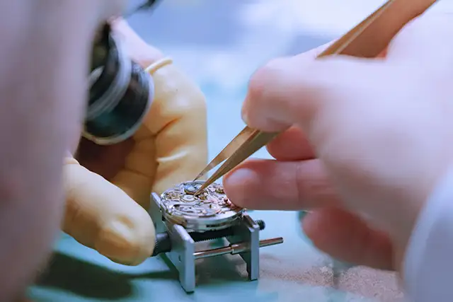 Artisan horloger travaillant sur une montre à complication à Genève