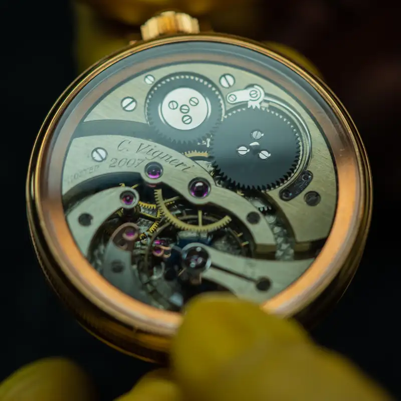 Expertise en restauration de montre vintage montrant les engrenages internes d'une pièce horlogère complexe