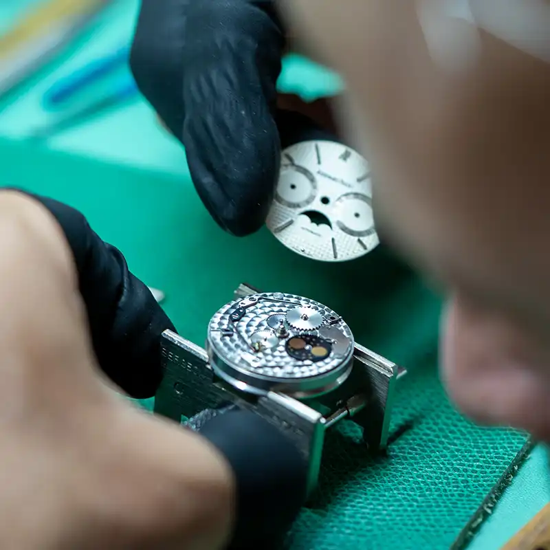Horloger procédant à la restauration d’un mouvement de montre à Genève – The Watch Lab Genève