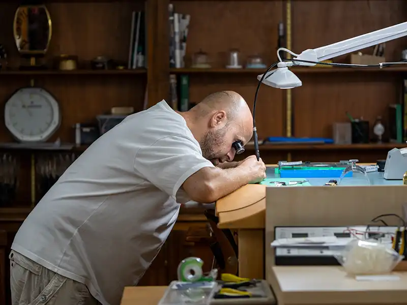 Horloger travaillant sur une montre dans l’atelier à Genève – The Watch Lab Genève