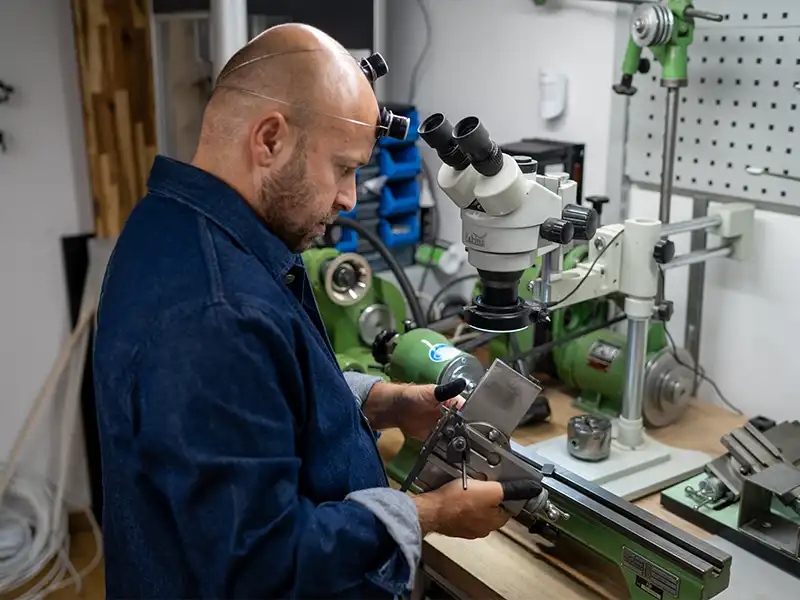 Horloger utilisant un outil de précision dans l’atelier de The Watch Lab Genève